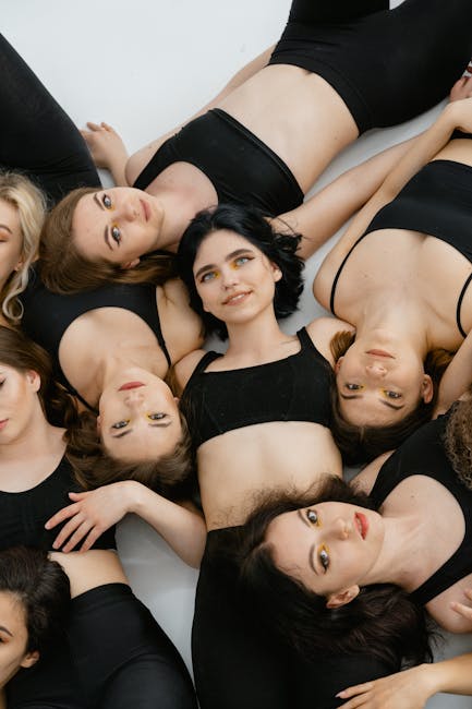 Diverse group of people smiling during a yoga class in a bright studio.